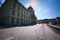 a person is walking down a cobblestone street in front of a building