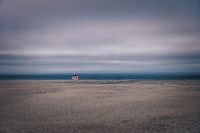 a red lifeguard tower on a sandy beach