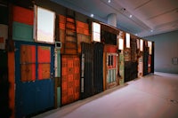 a wall of colorful doors in a museum