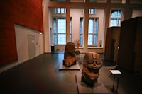 a room with a lot of statues on display