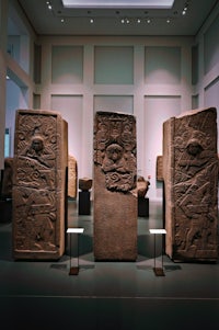 a group of stone sculptures in a museum