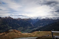 a person sitting on a bench overlooking a mountain range