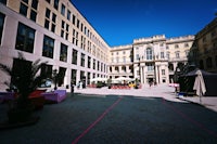 a courtyard with a building and a palm tree
