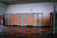 a row of wooden stalls in a bathroom