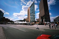 a red car driving down a city street