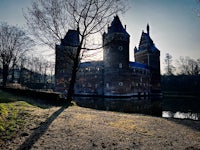 a castle sits next to a body of water