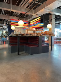 a bench in a restaurant with colorful lights hanging from it