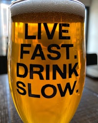 a beer glass with the words live fast drink slow on it