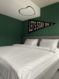 a bed in a room with green walls and a pennant