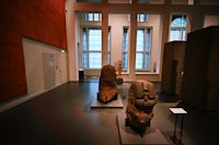 a room with a lot of statues on display