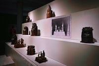 a display of carved wooden statues in a museum