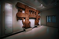 a wooden sculpture is on display in a museum