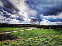 a cloudy sky over a grassy field